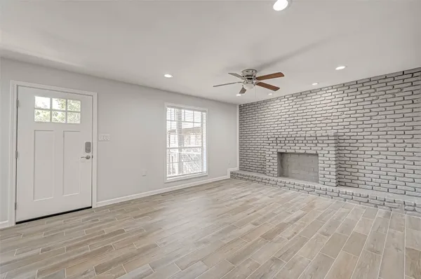 an empty room with windows and a fireplace