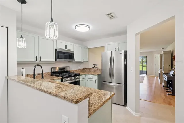 a kitchen with stainless steel appliances granite countertop a sink refrigerator and microwave