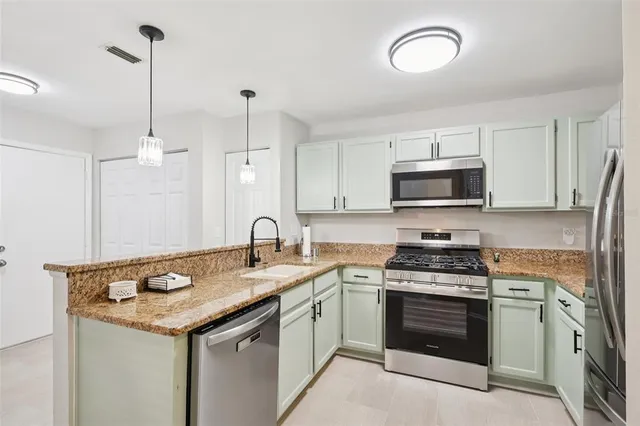 a kitchen with stainless steel appliances granite countertop a sink stove and microwave