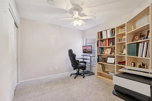 a view of a workspace with furniture and a book shelf