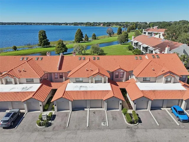 an aerial view of a house with a garden and lake view
