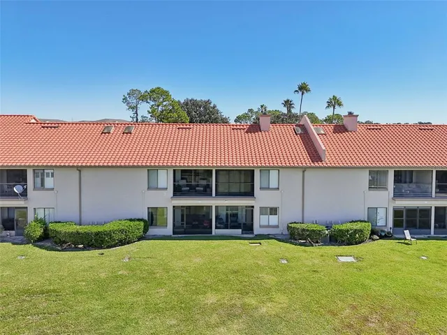 an aerial view of residential houses with outdoor space and trees