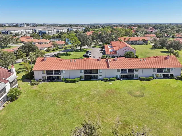 an aerial view of residential houses with outdoor space and lake view