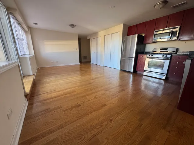 an empty room with wooden floor and electronic appliances