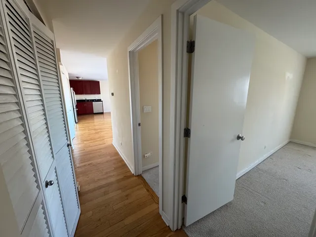 a view of a hallway with wooden floor and staircase