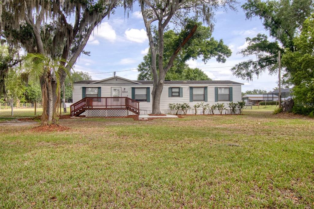 6804 Stafford Road Plant City, FL 33565 - Photo 1 of 24 a front view of a house with a yard fountain and trees