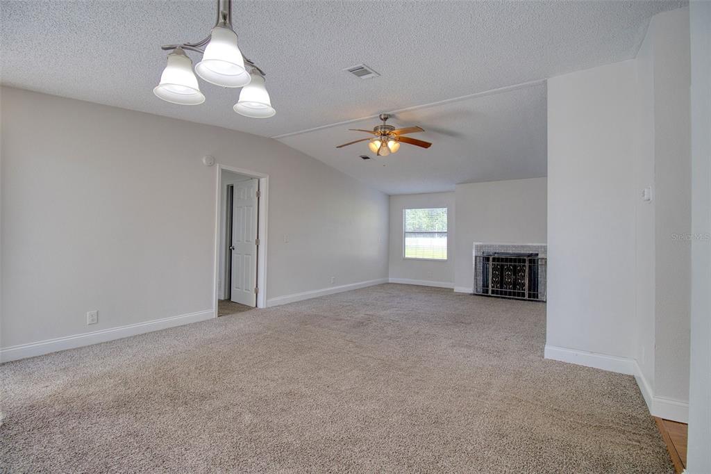 6804 Stafford Road Plant City, FL 33565 - Photo 4 of 24 an empty room with windows and fireplace