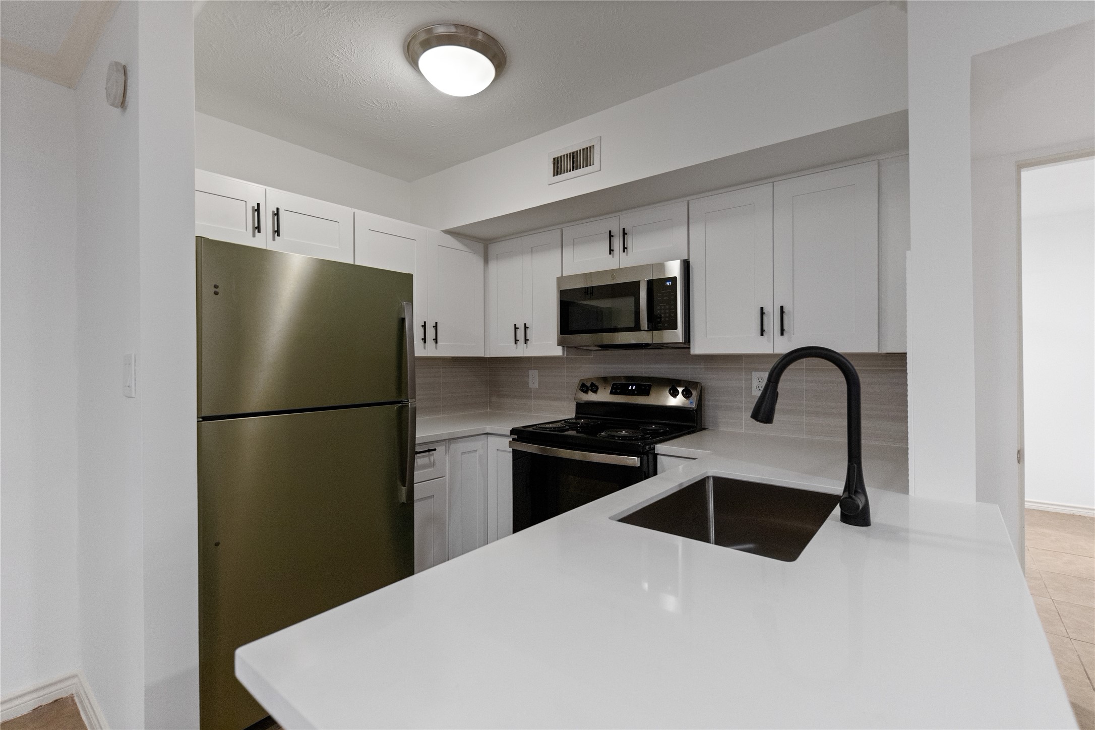 5353 Institute Lane, Unit 12 Houston, TX 77005 - Photo 6 of 15 a kitchen with stainless steel appliances a refrigerator stove microwave and sink