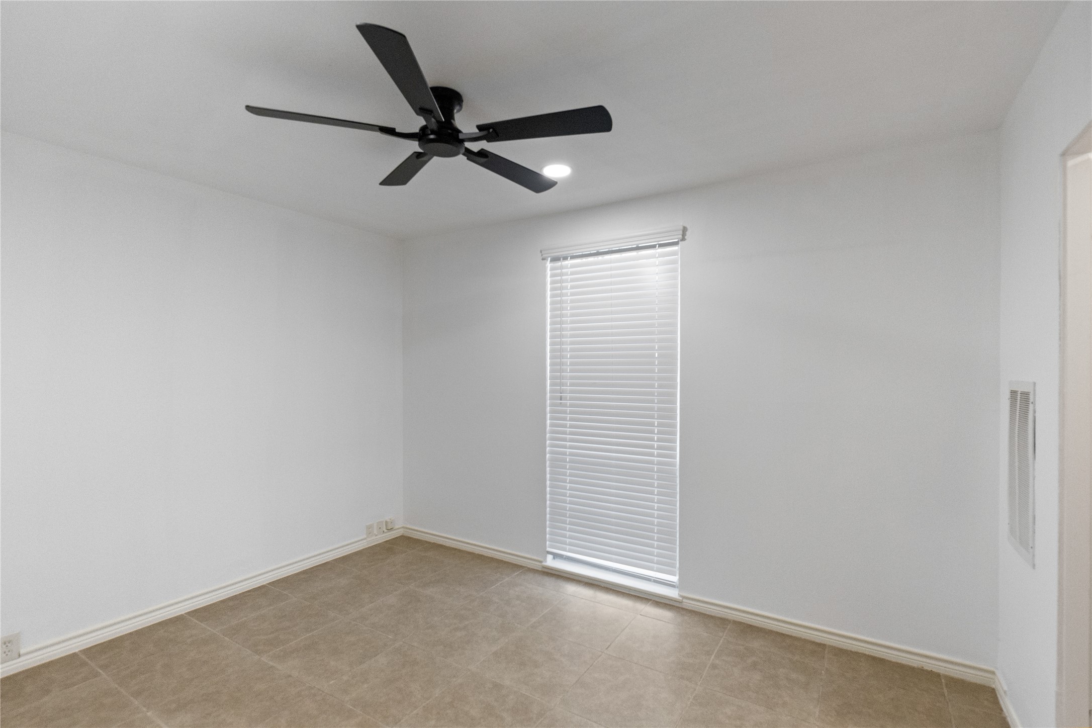 5353 Institute Lane, Unit 12 Houston, TX 77005 - Photo 8 of 15 an empty room with a ceiling fan and window