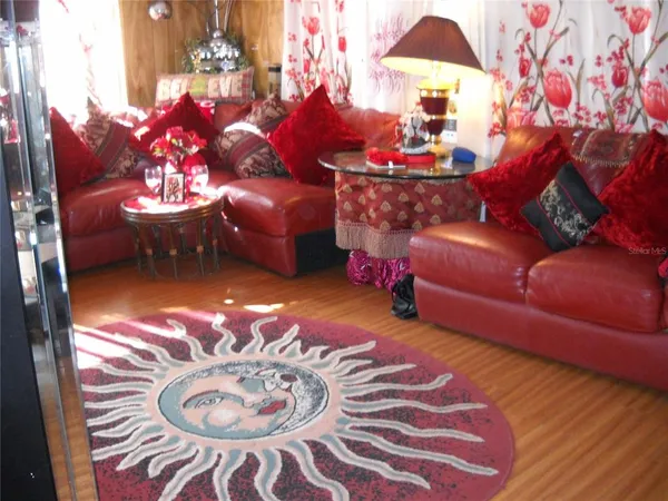 a living room with furniture a flat screen tv and a floor to ceiling window