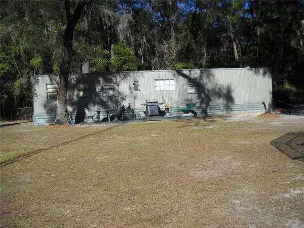 a view of a house with street that has a tree