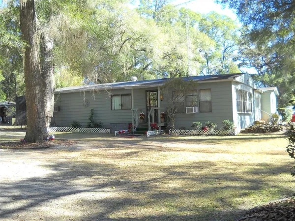 a view of a house with a yard and sitting area