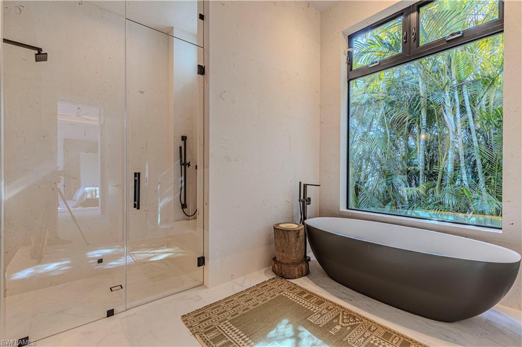 1100 Sandpiper Street Naples, FL 34102 - Photo 24 of 47 Waster bath with steam shower, oversized tub, full travertine stone wraped wall and window