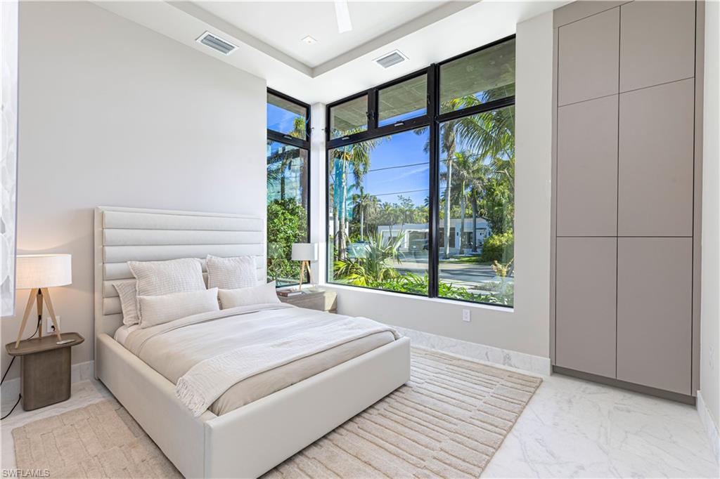 1100 Sandpiper Street Naples, FL 34102 - Photo 27 of 47 a bedroom with a large bed and a large window