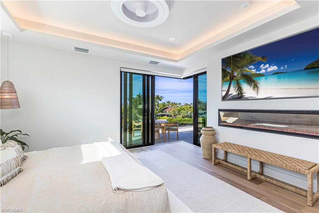 1100 Sandpiper Street Naples, FL 34102 - Photo 32 of 47 a bedroom with a bed and a potted plant