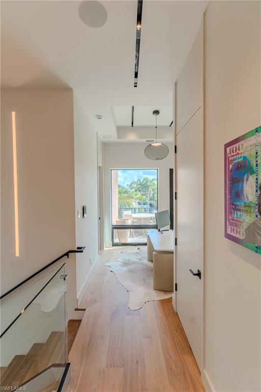 1100 Sandpiper Street Naples, FL 34102 - Photo 36 of 47 Corridor with light wood-type flooring and baseboards