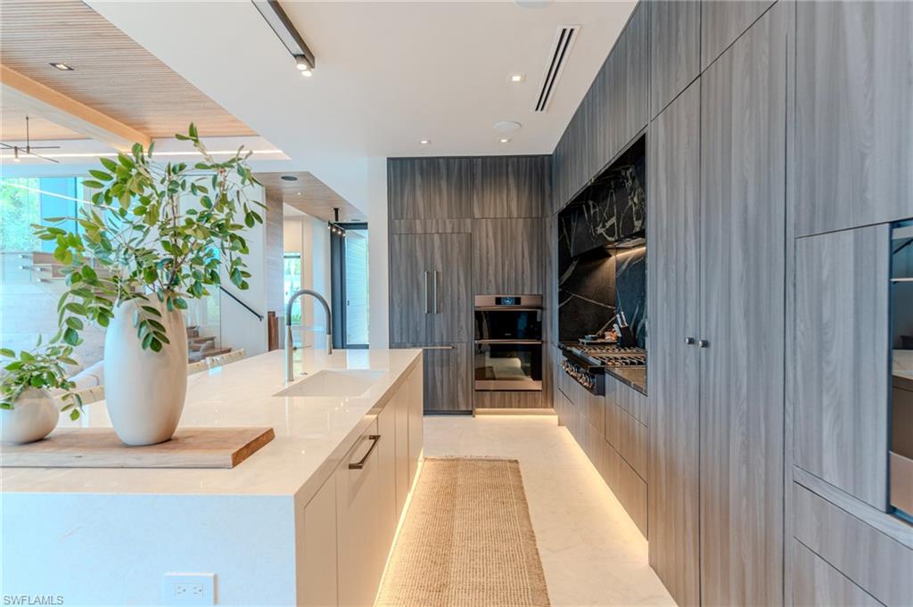 1100 Sandpiper Street Naples, FL 34102 - Photo 4 of 47 a dining hall with stainless steel appliances kitchen island granite countertop a living room view