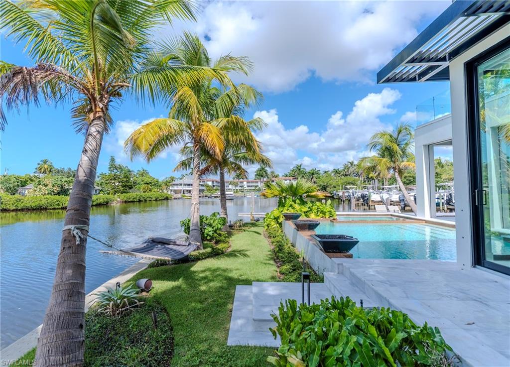 1100 Sandpiper Street Naples, FL 34102 - Photo 9 of 47 Swimming pool featuring a water view, a yard, and a patio area