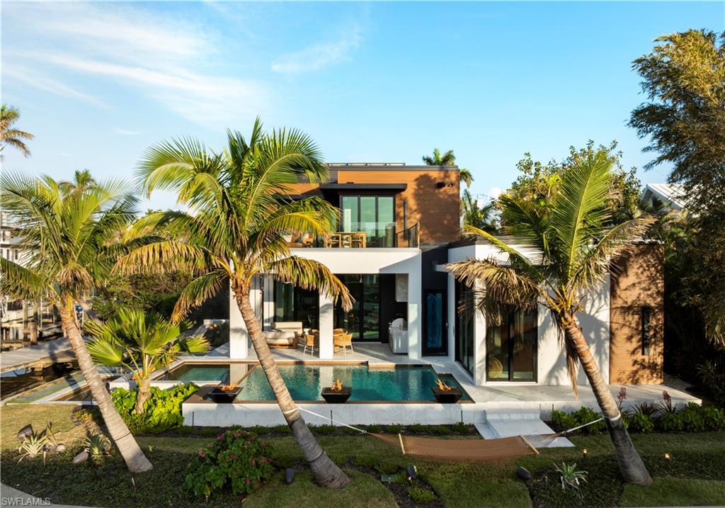 1100 Sandpiper Street Naples, FL 34102 - Photo 10 of 47 Rear view of property with a swimming pool with hot tub, a balcony, and a patio