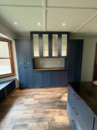 an empty room with wooden floor windows and a ceiling fan