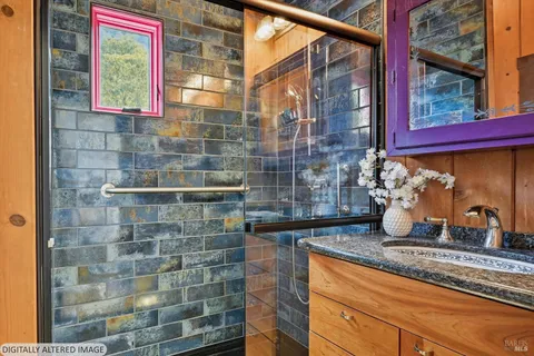 a bathroom with a granite countertop sink a window and shower