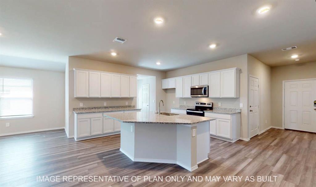 10204 Neptune Court Waco, TX 76708 - Photo 6 of 20 Kitchen featuring an island with a sink, white cabinetry, granite-style countertops, stainless steel microwave, and wood-finish flooring