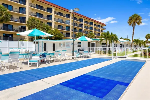 a view of a swimming pool with a table and chairs under an umbrella