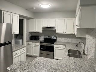 4226 Walnut Hills Drive, Unit 3 Corpus Christi, TX 78413 - Photo 5 of 11 a kitchen with a refrigerator stove and sink