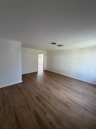 a view of an empty room and wooden floor