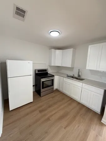 a kitchen with granite countertop white cabinets and white appliances