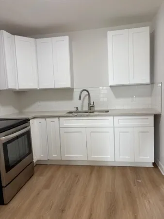 a kitchen with granite countertop white cabinets and sink