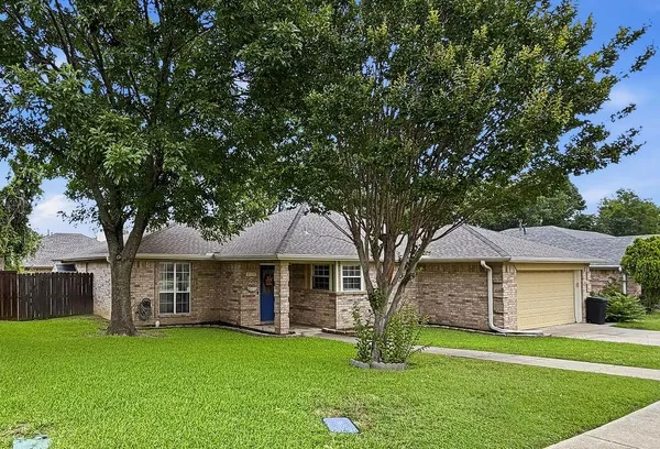 a front view of a house with a garden and yard
