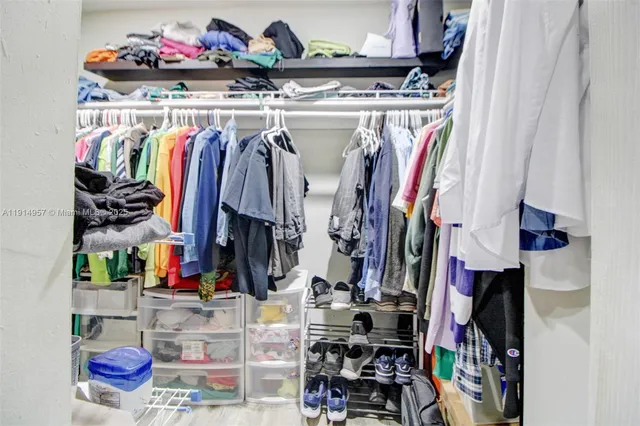 a view of walk in closet with clothes and shoes