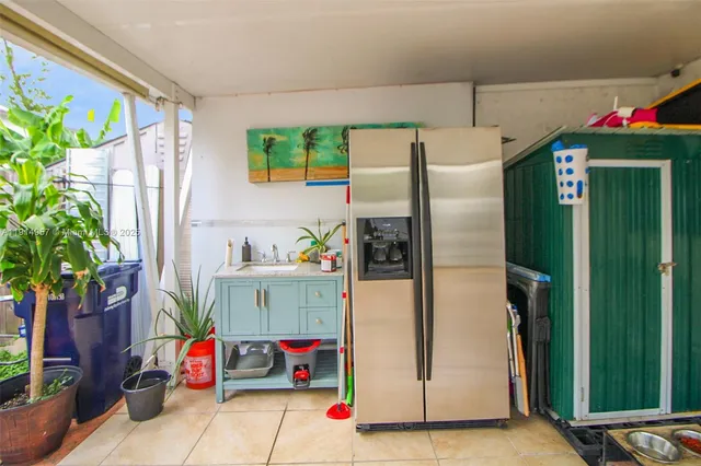 a kitchen with stainless steel appliances a refrigerator and a potted plant