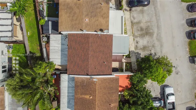an aerial view of residential house with outdoor space and trees all around