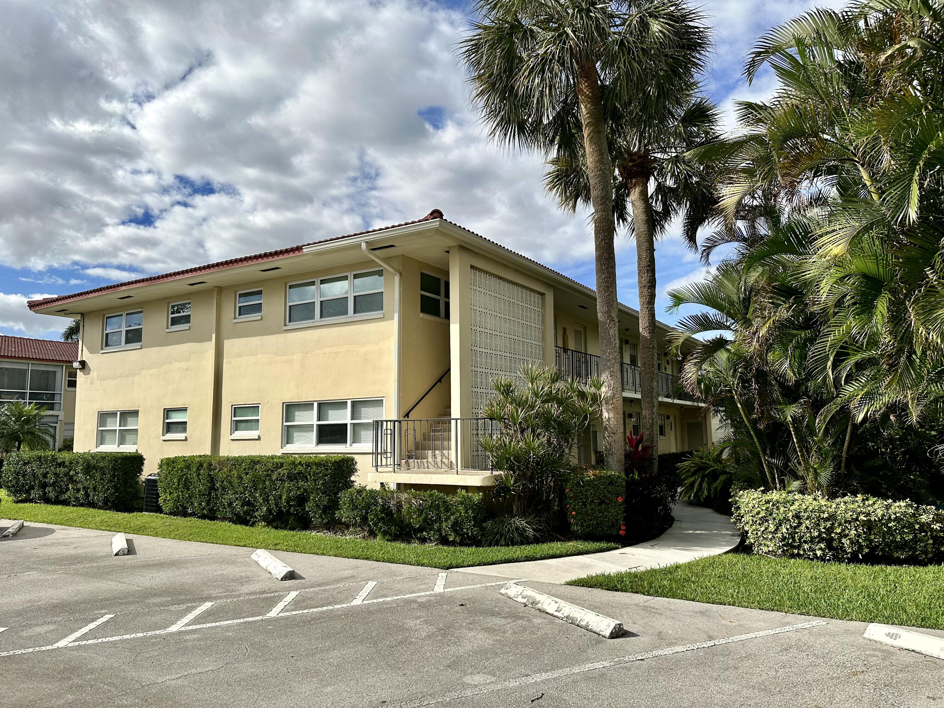 2162 Northeast 36th Street, Unit 46 Lighthouse Point, FL 33064 - Photo 14 of 15 a front view of a house with a garden and tree