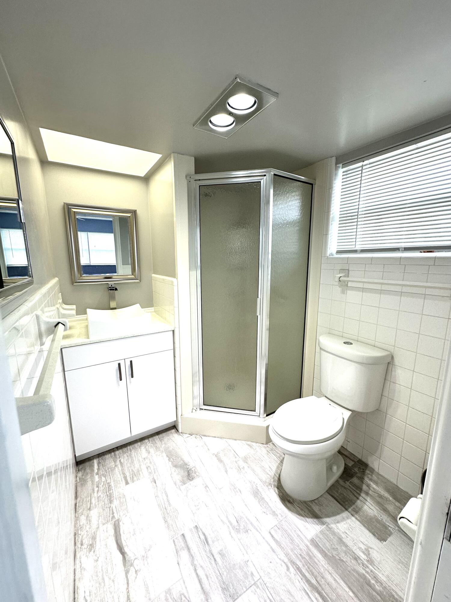 2162 Northeast 36th Street, Unit 46 Lighthouse Point, FL 33064 - Photo 8 of 15 a bathroom with a sink toilet a mirror and vanity