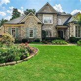 a front view of a house with a garden and plants
