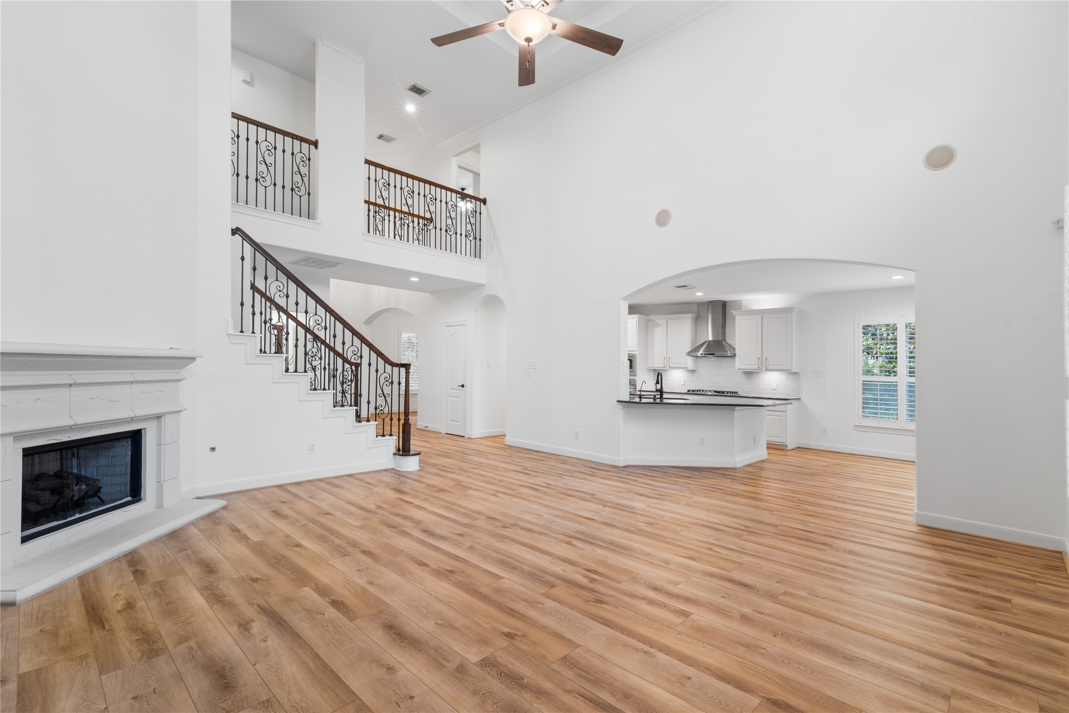 155 South Arrow Canyon Circle Spring, TX 77389 - Photo 17 of 49 a view of an empty room with a fireplace a chandelier and wooden floor