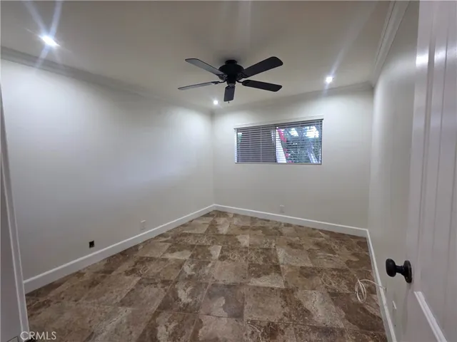 an empty room with closet and a ceiling fan