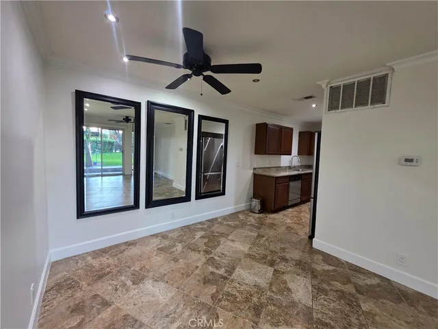 a view of a livingroom with a flat screen tv wooden floor and kitchen space