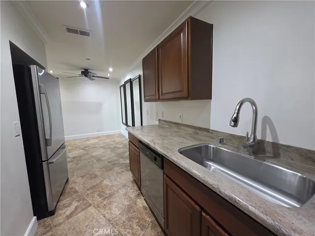 a kitchen with granite countertop stainless steel appliances and wooden cabinets