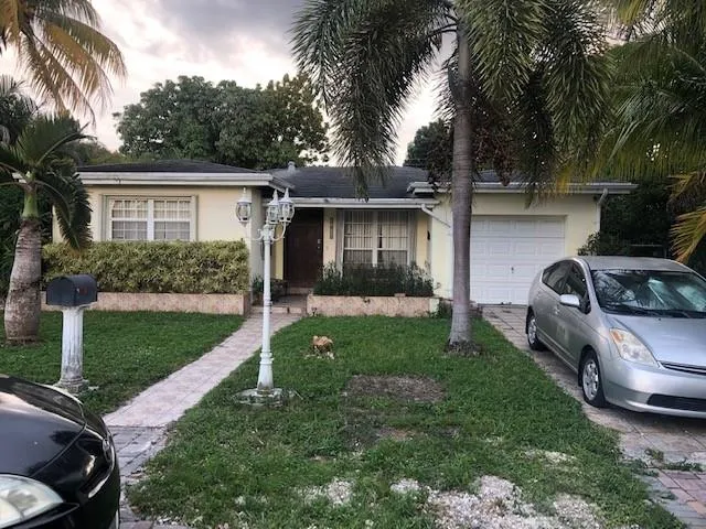 a view of a backyard with couches plants and large trees