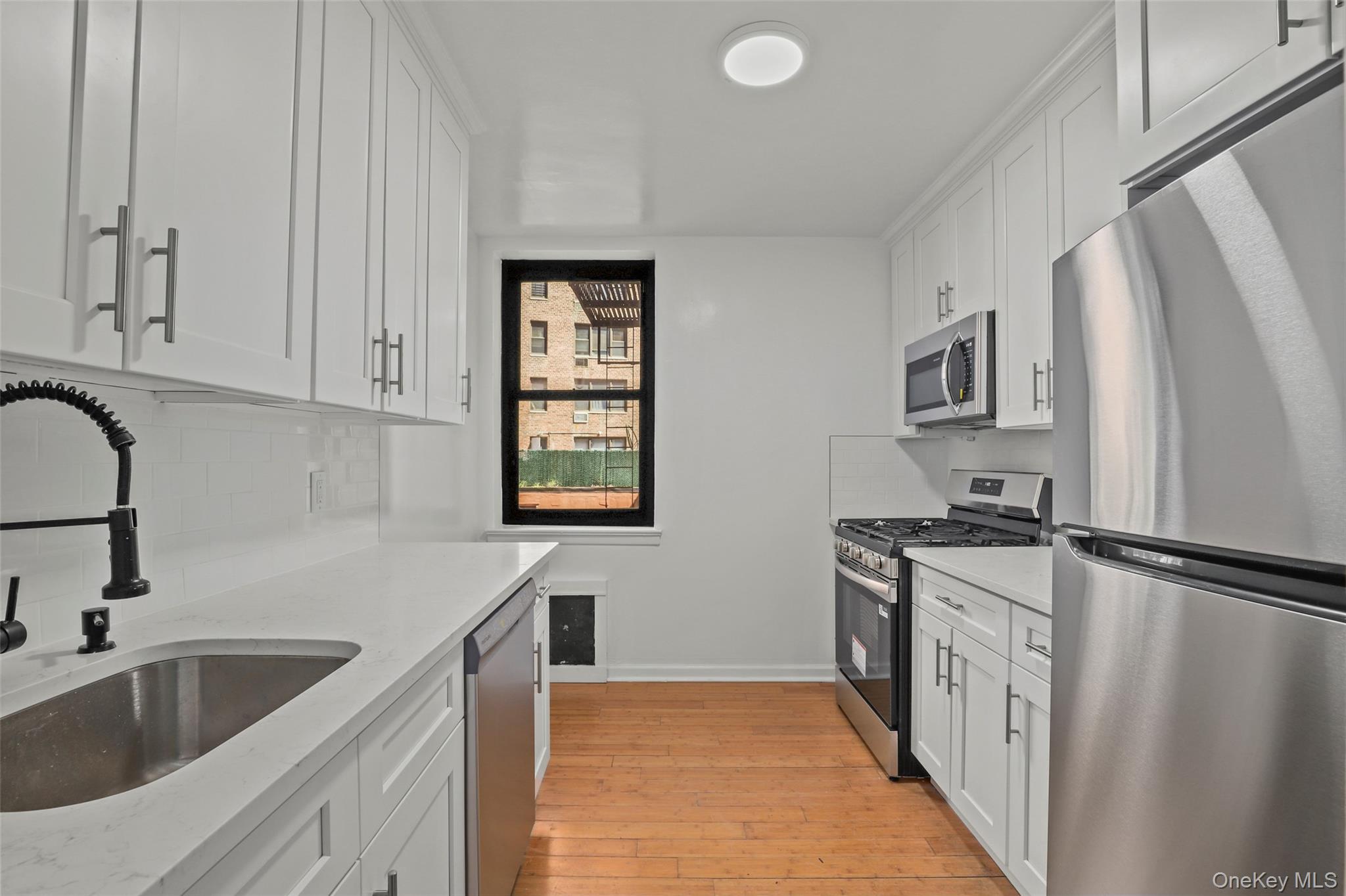 555 Bronx River Road, Unit 1J Yonkers, NY 10704 - Photo 2 of 11 a kitchen with granite countertop a sink stove and refrigerator