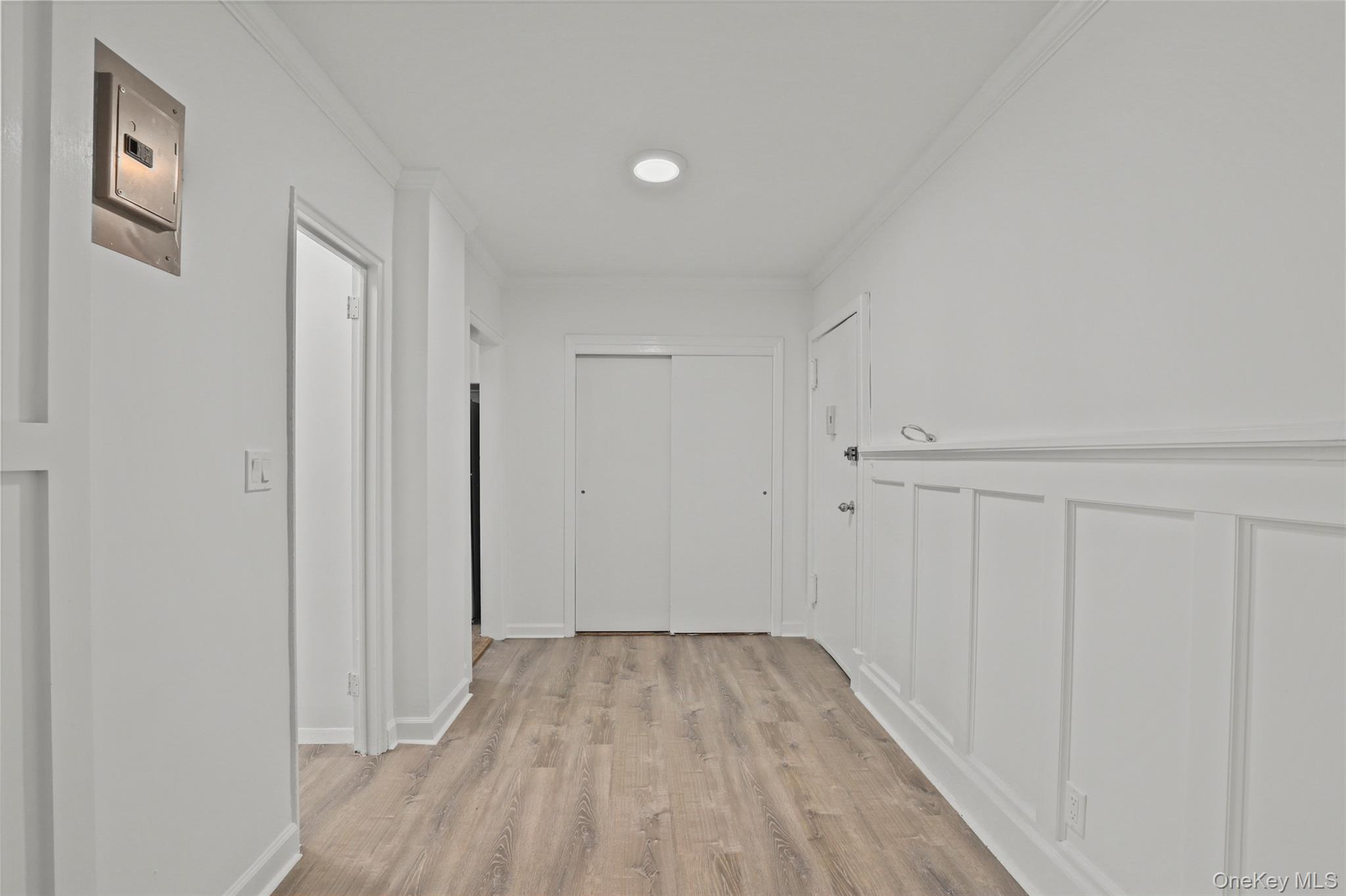 555 Bronx River Road, Unit 1J Yonkers, NY 10704 - Photo 6 of 11 Corridor featuring crown molding, light wood finished floors, and electric panel