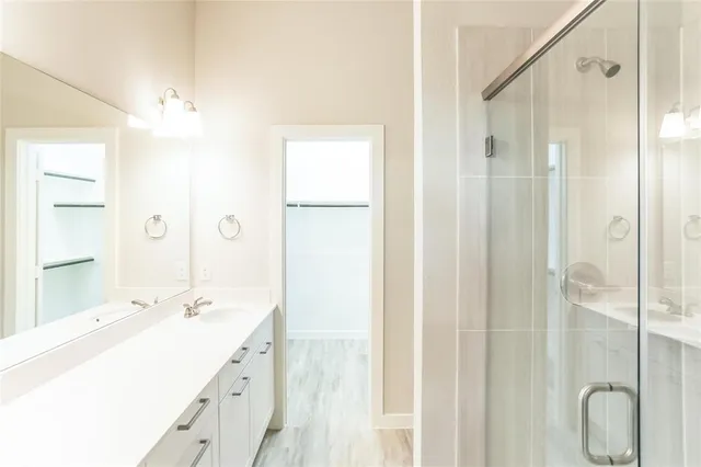a spacious bathroom with a shower sink and mirror
