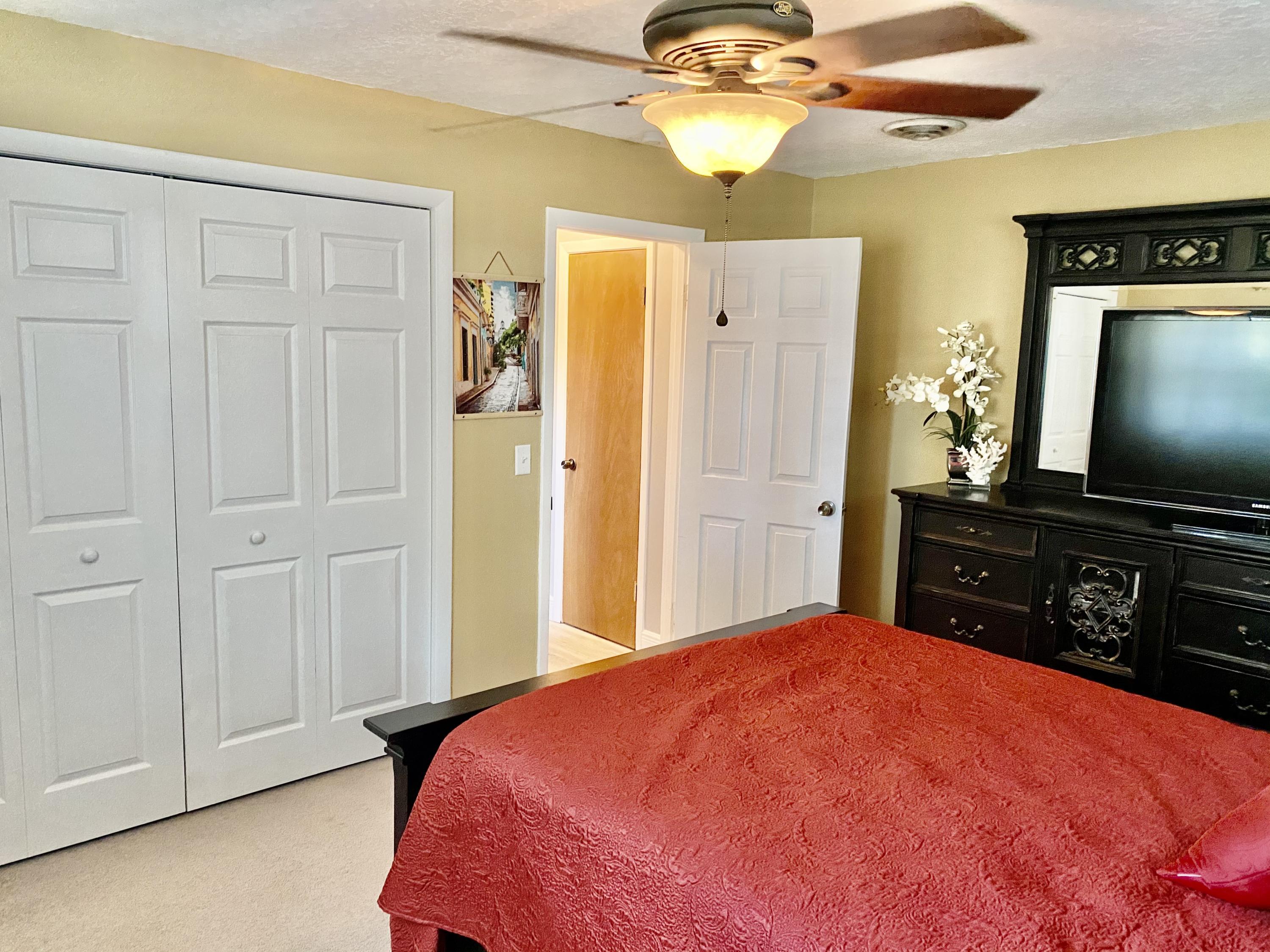 993 Cardon Drive Rockledge, FL 32955 - Photo 13 of 22 a bedroom with a bed and a flat tv screen on the dresser