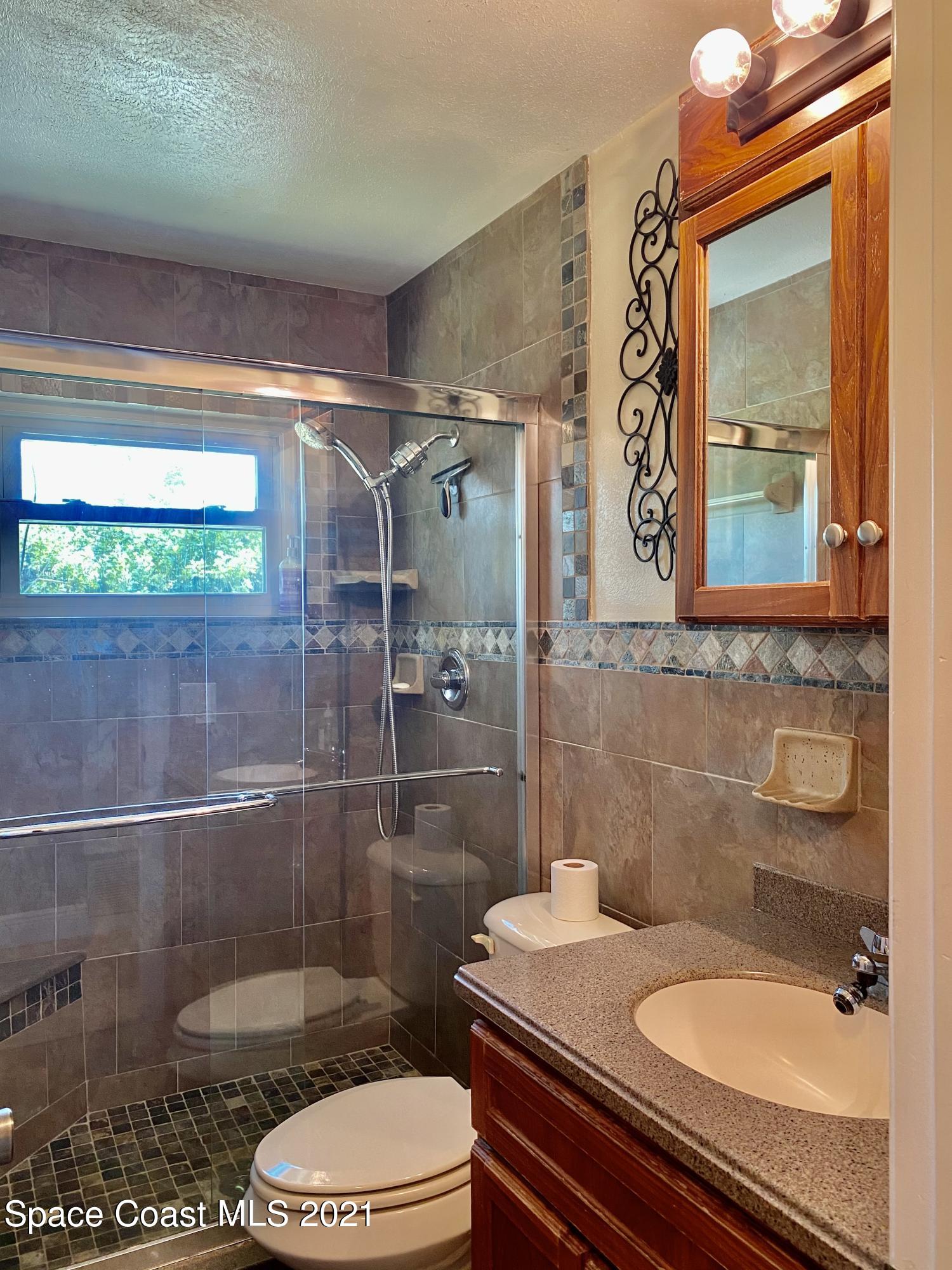 993 Cardon Drive Rockledge, FL 32955 - Photo 14 of 22 a bathroom with a sink a toilet and shower