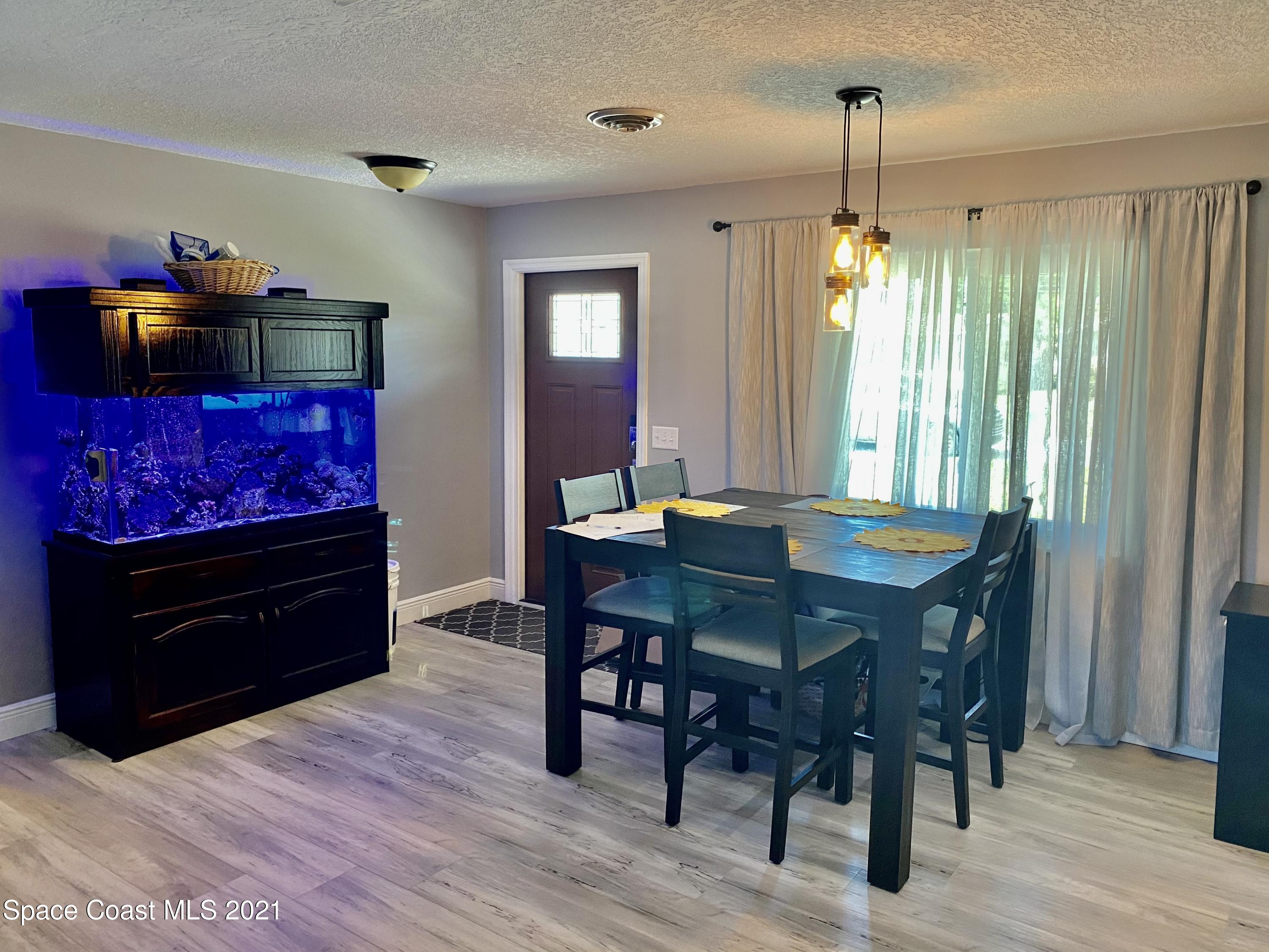 993 Cardon Drive Rockledge, FL 32955 - Photo 6 of 22 a view of a dining room with furniture window and wooden floor