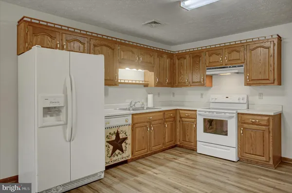 a kitchen with stainless steel appliances white cabinets and wooden floor
